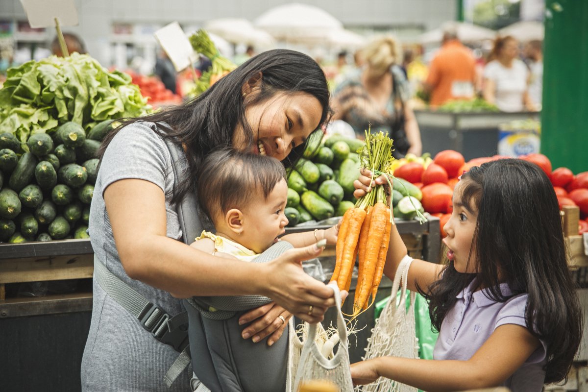 parent and children shopping for fresh produce made possible in part by the child tax credit and food assistance programs