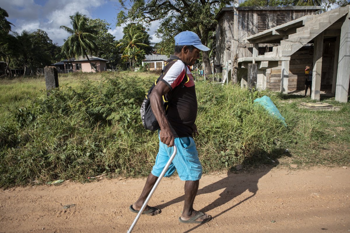 An injured lobster diver walks through Puerto Lempira on his way to a clinic that provides basic services to divers. (Photo credit: Jacky Muniello)