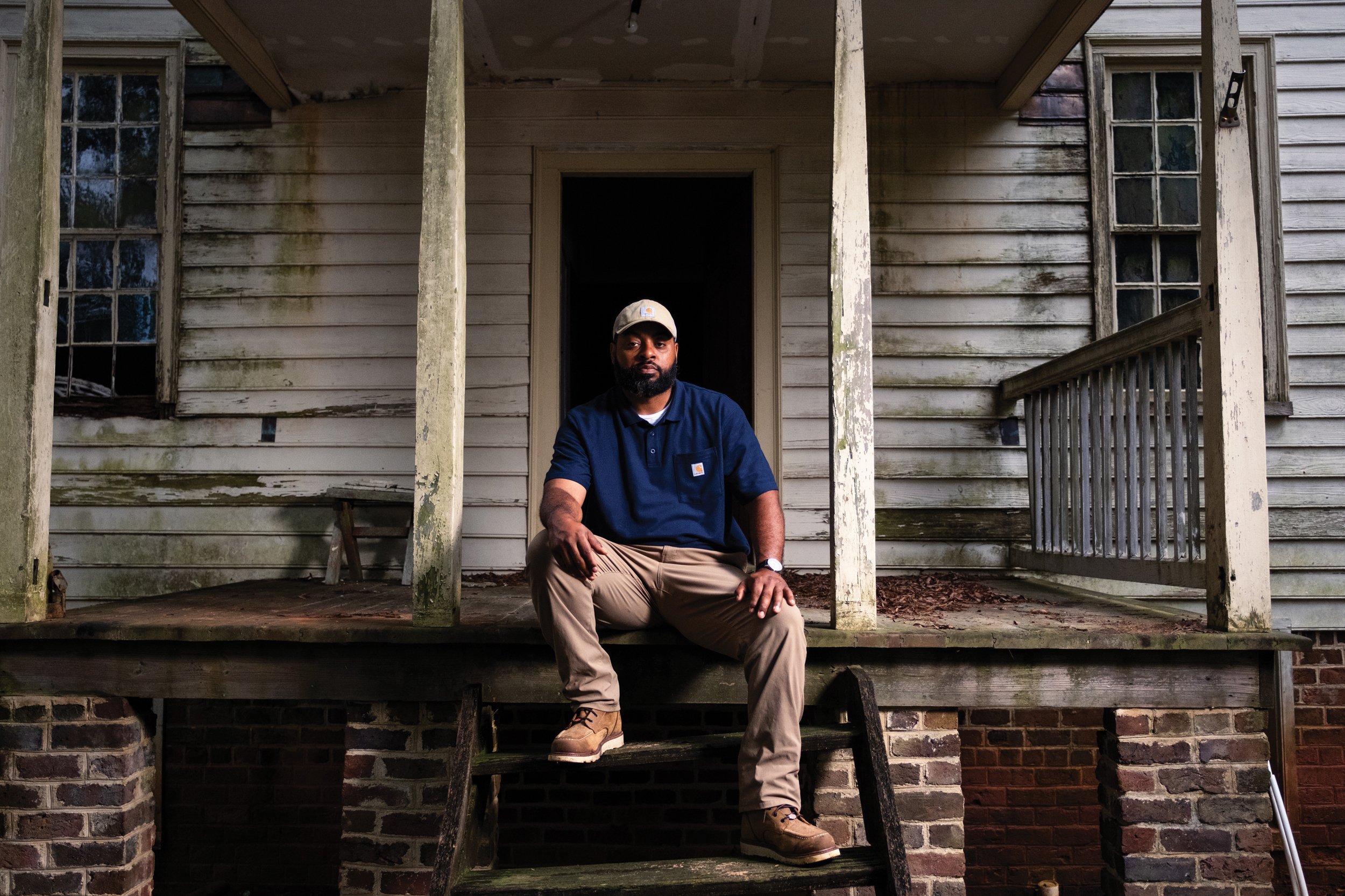 Fourth-generation farmer Patrick Brown sits on the steps of the Oakley Grove plantation, where his great-grandfather Byron was enslaved. Brown purchased the plantation in May 2021 and is in the process of renovating it. (Photo credit: Cornell Watson)