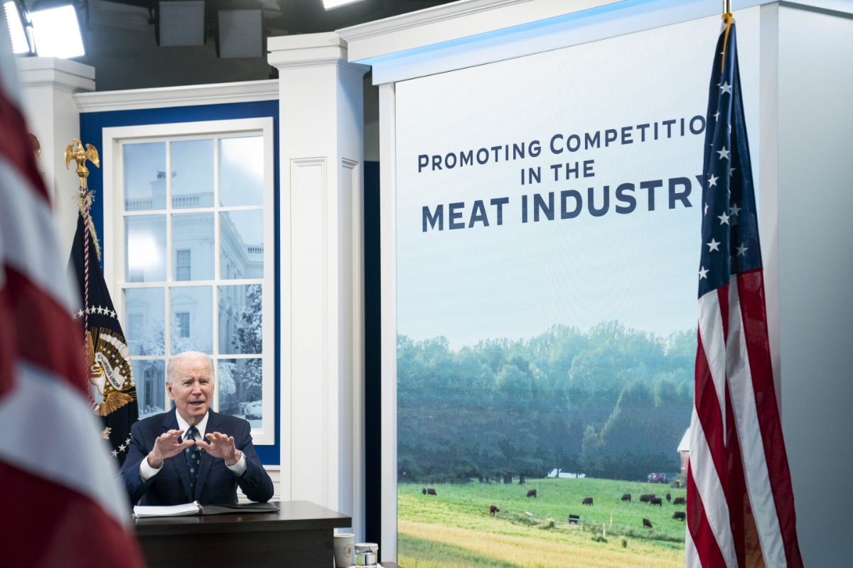 U.S. President Joe Biden speaks during a virtual meeting about reducing the costs of meat through increased competition in the meat processing industry in the South Court Auditorium at the Eisenhower Executive Office Building on January 3, 2022 in Washington, DC. President Biden heard from Attorney General Merrick Garland, Secretary of Agriculture Tom Vilsack, and independent farmers. (Photo credit: Sarah Silbiger/Getty Images). Image of Biden sitting at a desk with a big image stating