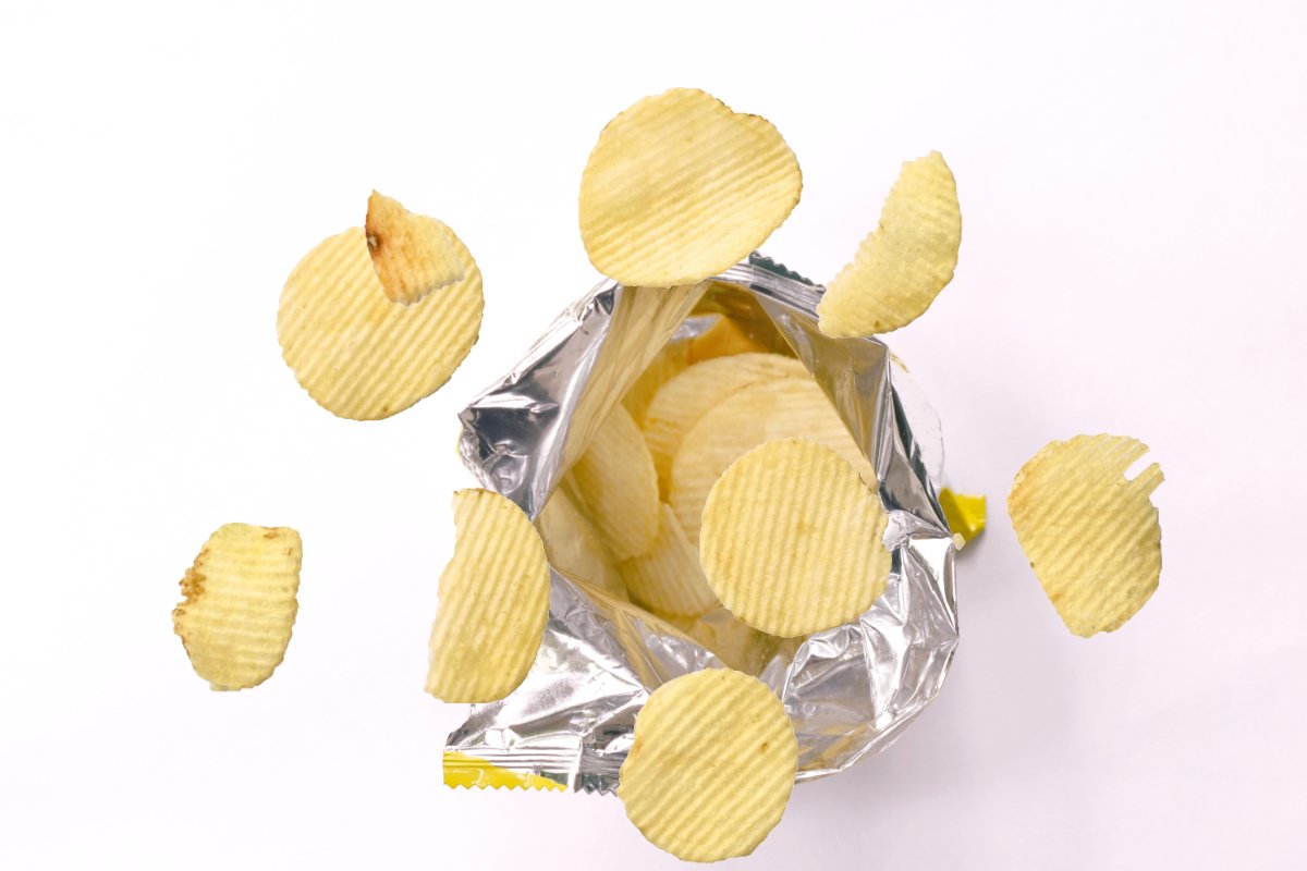 potato chip floating over aluminium foil packaging isolated on white background