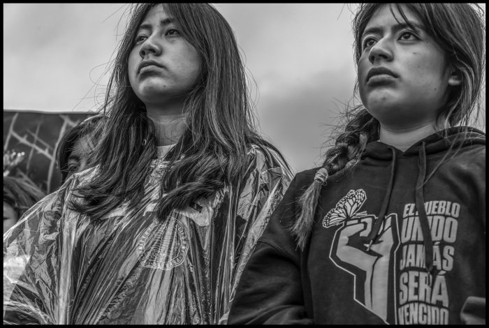 Two young women listen to Vasquez speak at the march. (Photo credit: David Bacon)