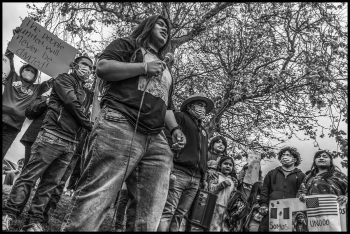 Cesar Vasquez shouts out his poem to the crowd of marchers on March 30. (Photo credit: David Bacon)