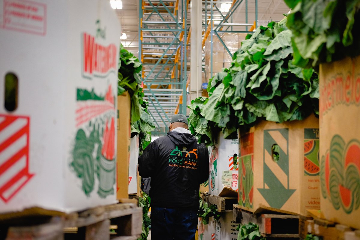 A warehouse staff moves through rows of food at the Capital Area Food Bank. (Photo: Capital Area Food Bank)