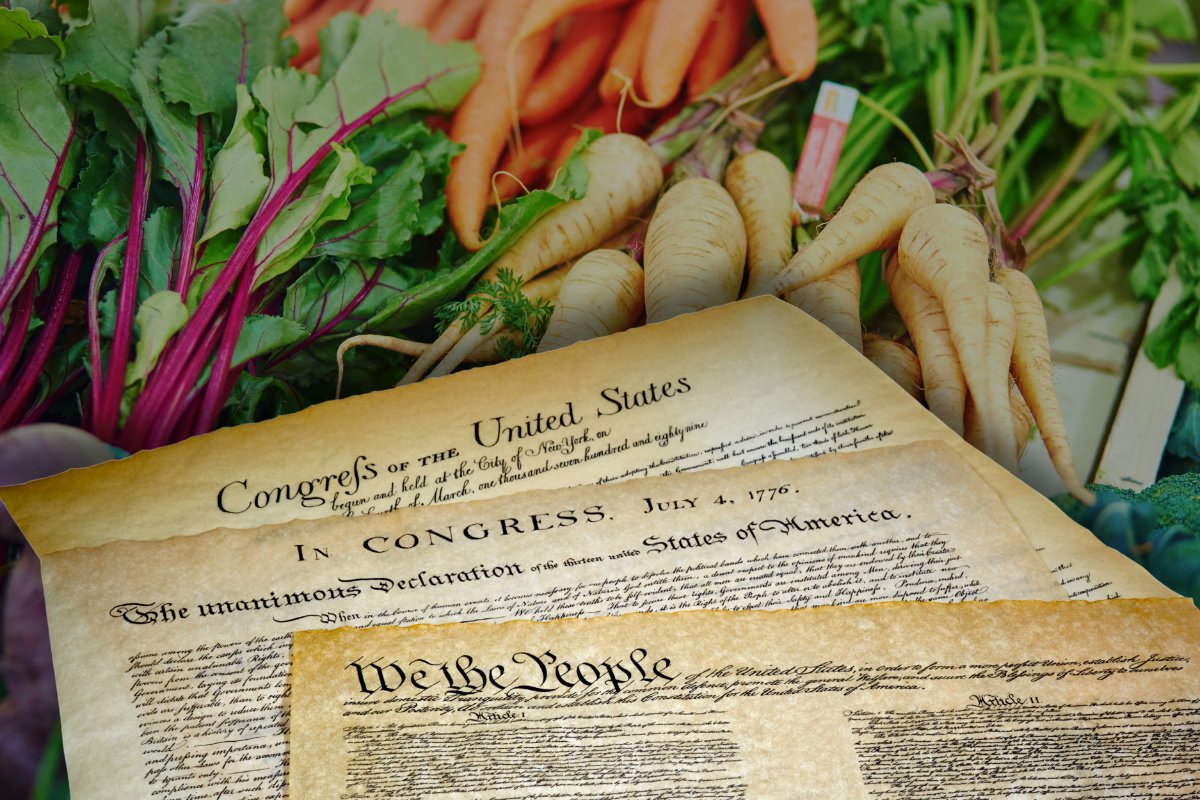 Photo illustration of the U.S. Constitution, Declaration of Independence, and the Bill of Rights laying on top of an image displaying bundles of root vegetables.