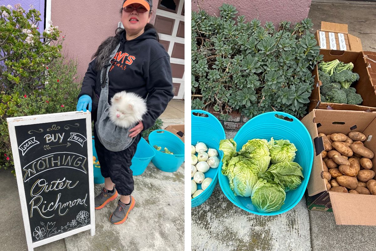 A woman wearing a Giant's baseball hat and hoodie holds her white pomeranian in a bag, next to a chalkboard sign that says 